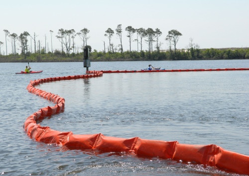 Kayakers at Naval Air Station Pensacola detour around oil containment boom at...