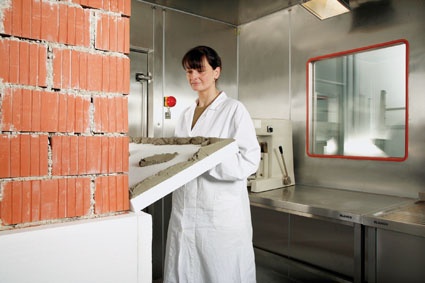 Experiments in the climatic chamber: an employee affixes a Vinnapas-modified...