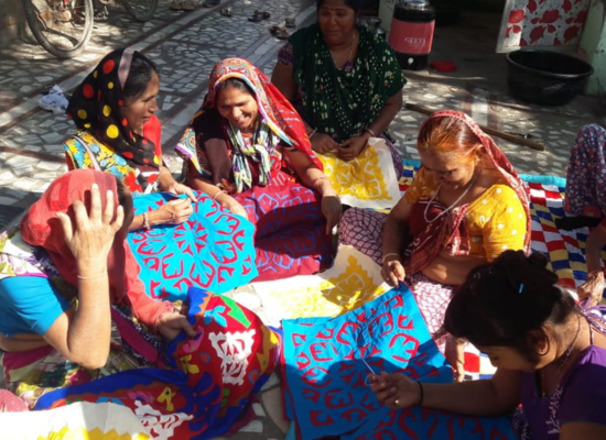 Group of women working on various textiles.