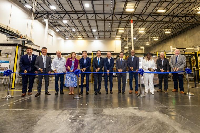 Attendees participate in a ribbon-cutting ceremony
